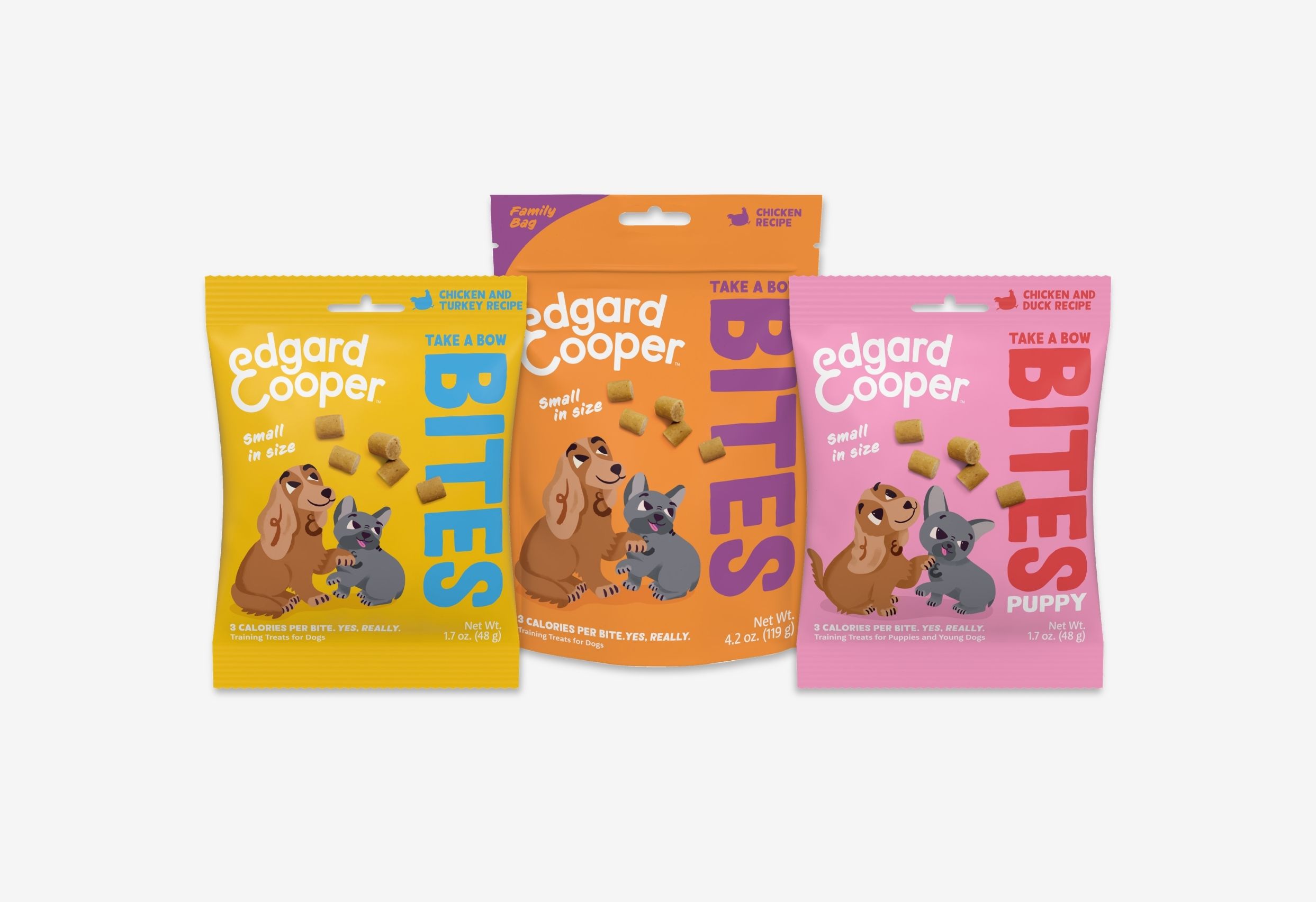 Three colorful pouches with different flavors of Edgard & Cooper's "Take A Bow Bites" dog treats. 