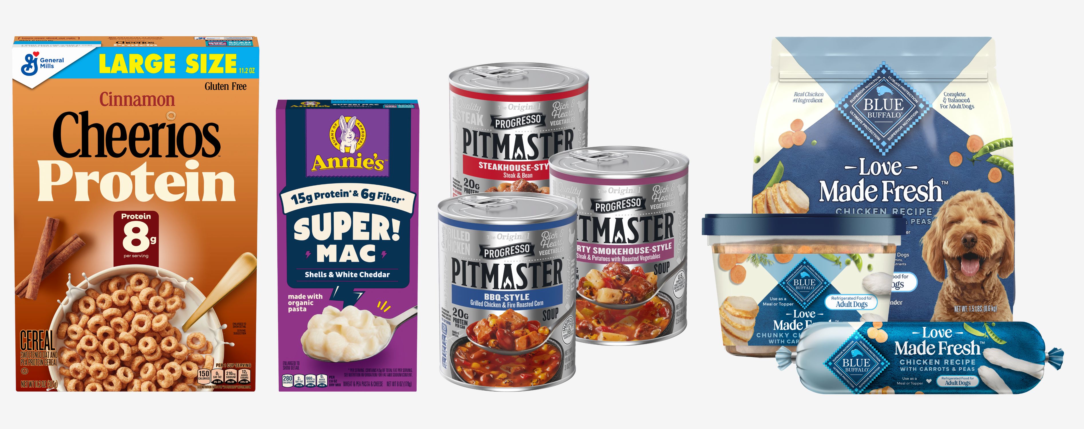 This image displays a collage of modern General Mills products. On the left is a box of "Cinnamon Cheerios Protein" cereal and a box of "Annie's Super! Mac" (shells & white cheddar). On the right are three cans of "Progresso Pitmaster" soup (Steakhouse-Style Chili, BBQ-Style Chili, and Smokehouse-Style Chili), alongside various "Blue Buffalo Love - Made Fresh" dog food products, including kibble, wet food, and a fresh food roll.